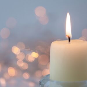 Kerze vor glitzerndem, leuchtenden Hintergrund